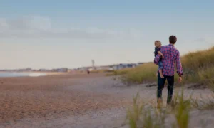 father standing with child on beach